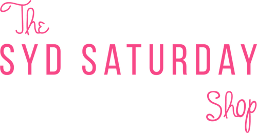 Pink text reading 'The SYD SATURDAY Shop' on a solid black background.