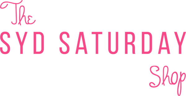 Pink text reading 'The SYD SATURDAY Shop' on a solid black background.